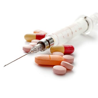 Photo of A syringe and an assortment of steoroid pills